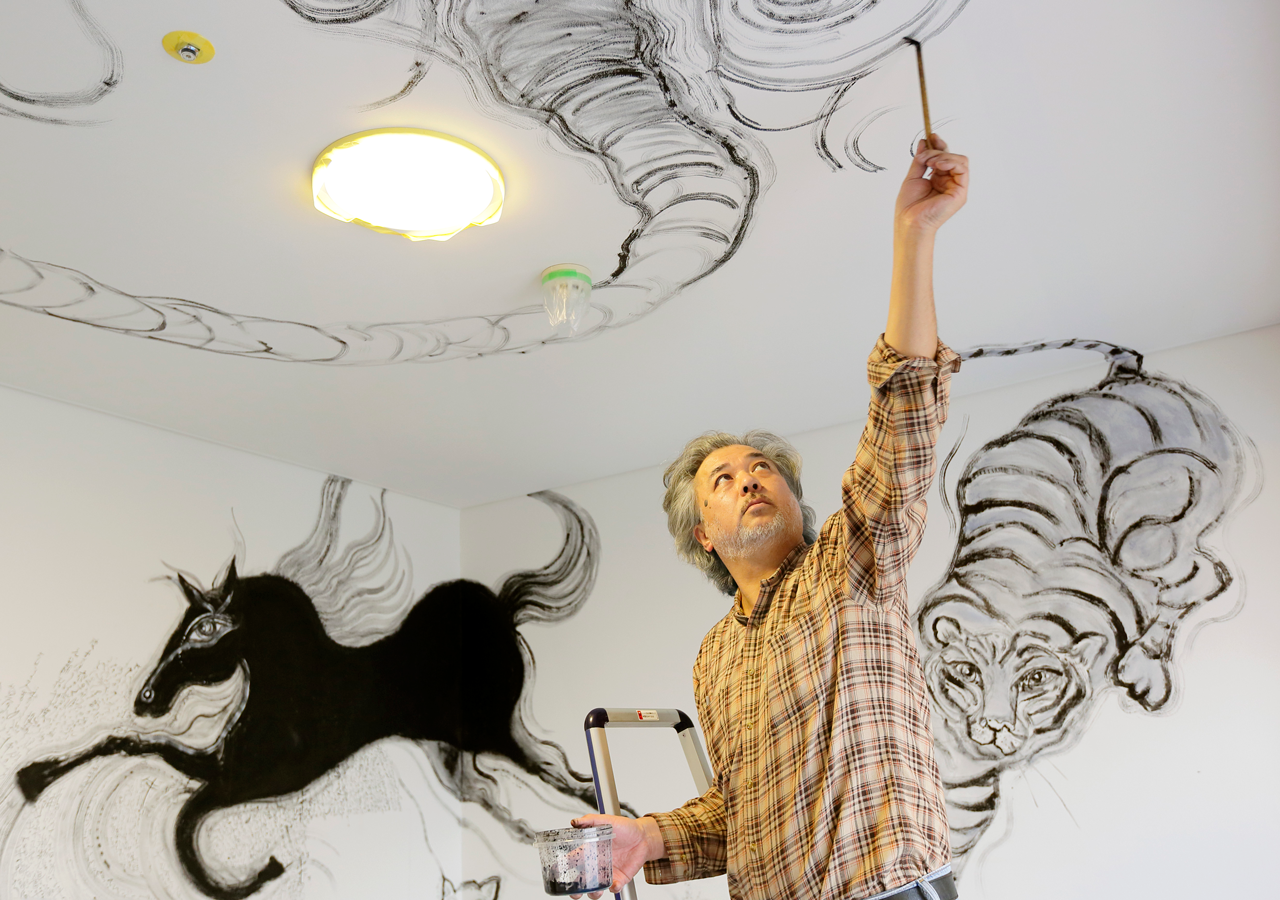 Artist Ryosuke Yasumoto works on his Chinese zodiac-themed room.