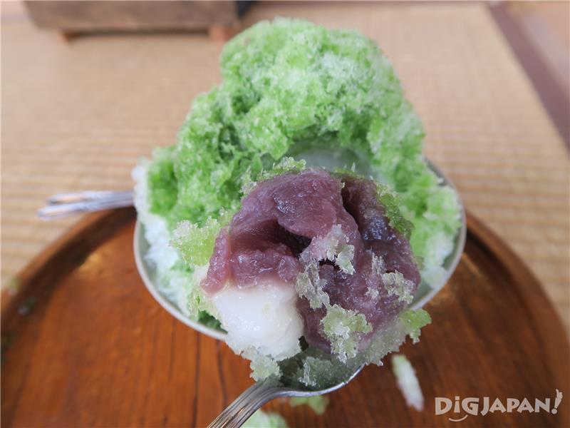 Beneath a mound of green tea-flavored shaved ice are hidden rice cakes and bean paste